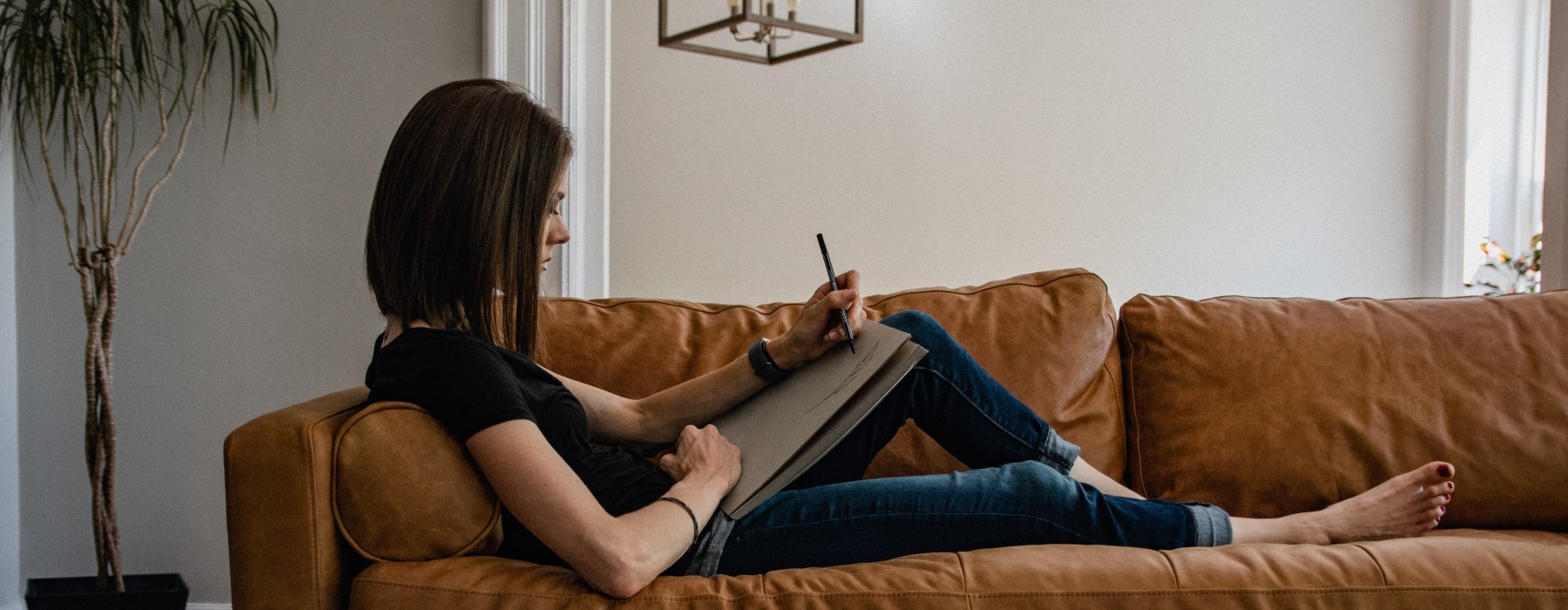 a woman writing on a sofa